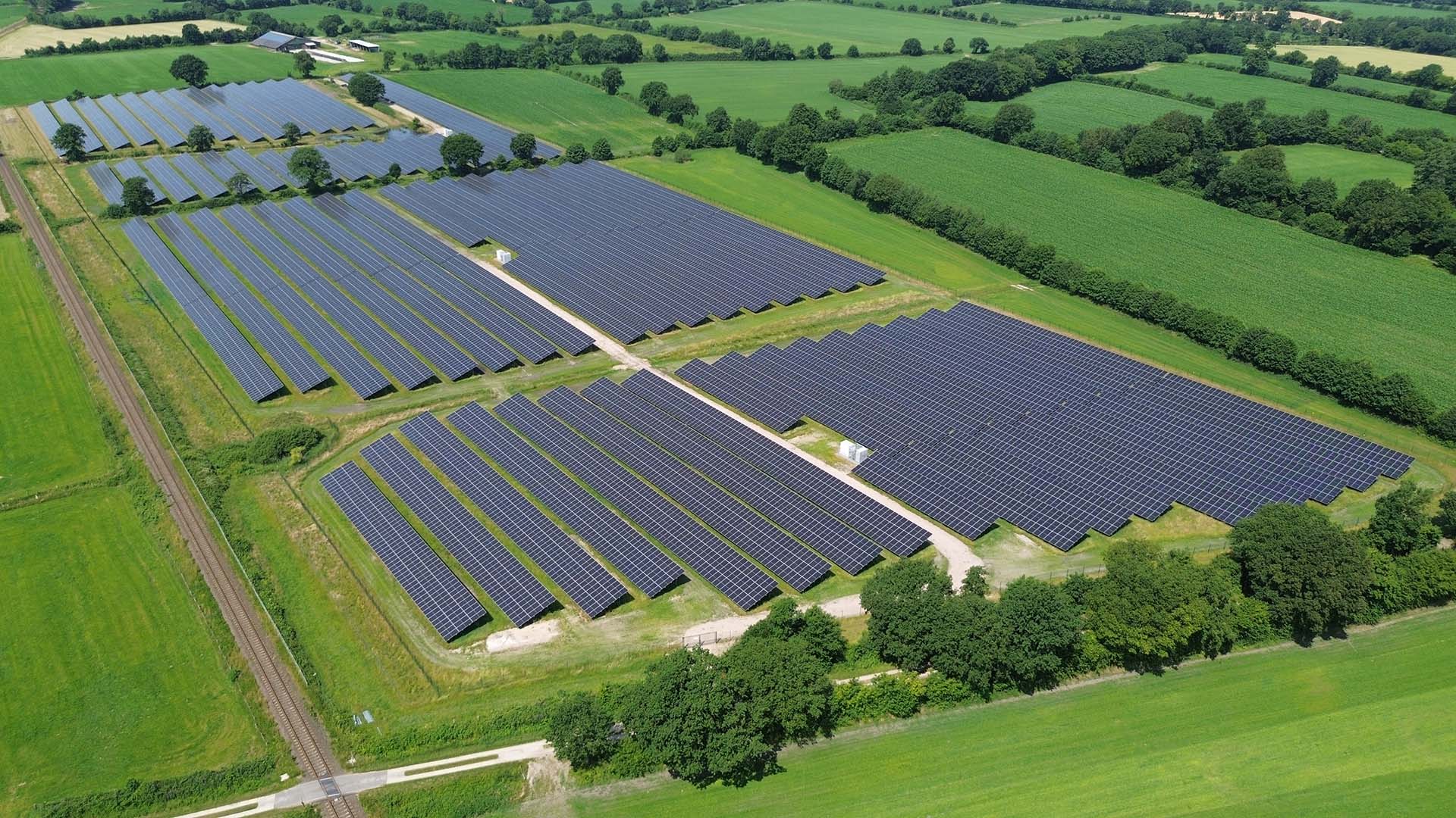Eine PV-Freiflächenanlage in Steenfeld von oben, umringt von grünen Feldern und Knicks.